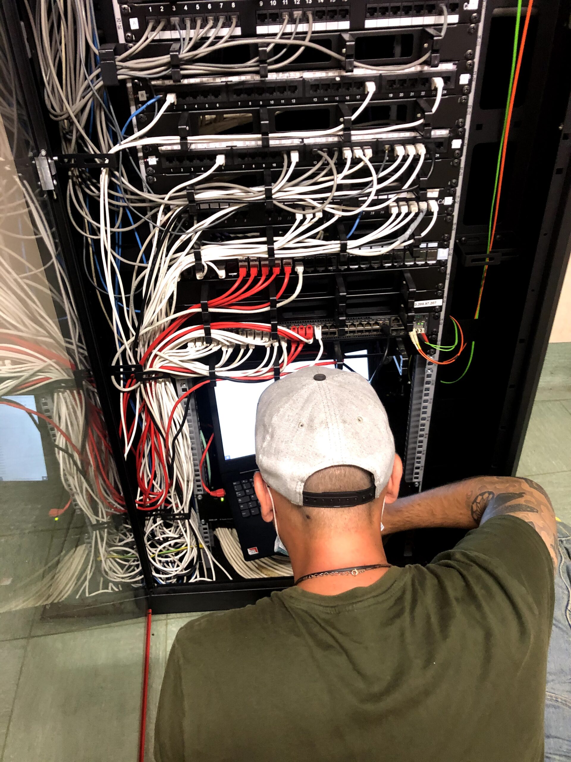 Tecnico DIVISOZERO al lavoro su un armadio rack con cablaggio strutturato